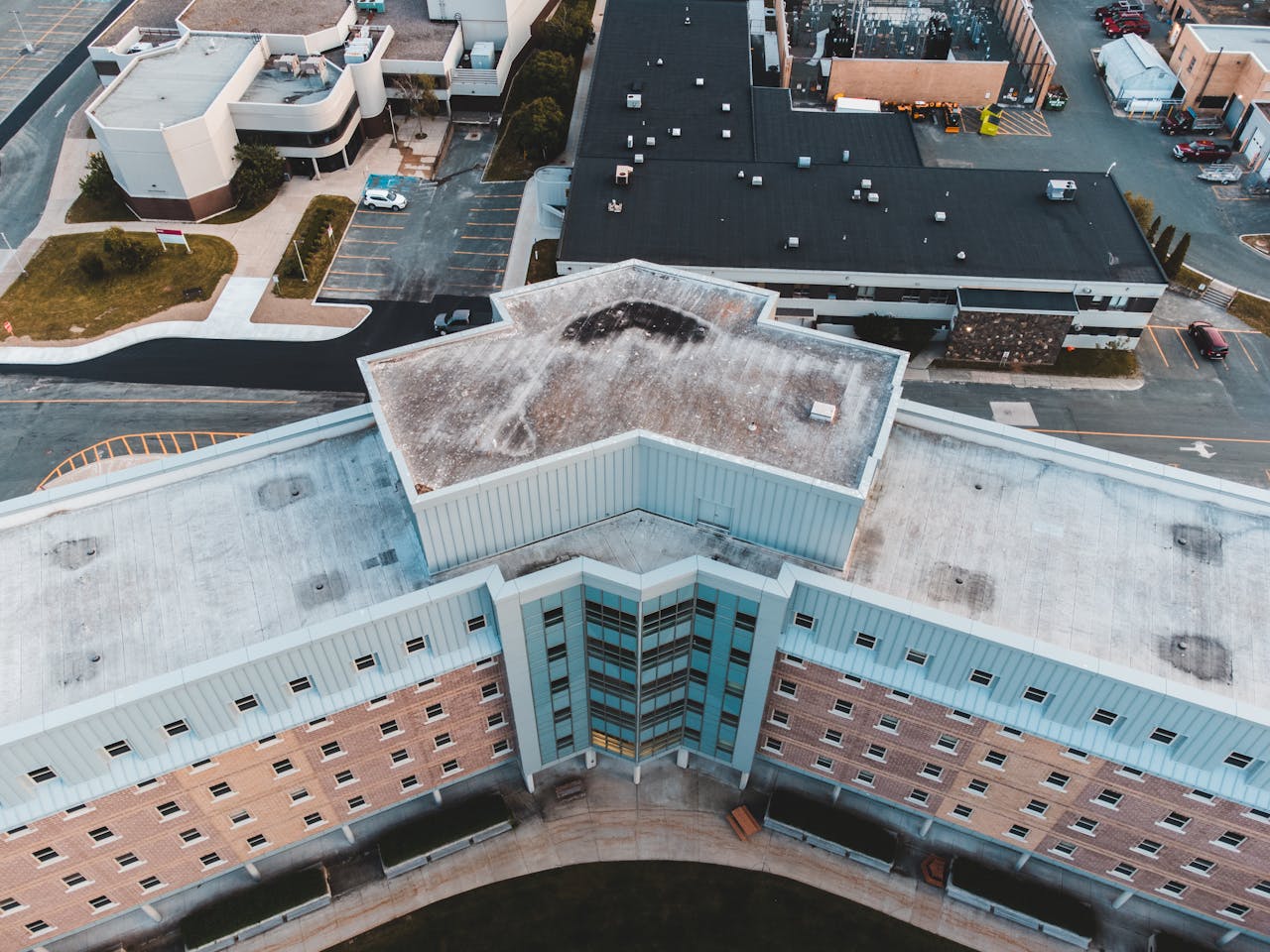 Offerings Drone view capturing the geometric rooftop of a high-rise building in an urban area.